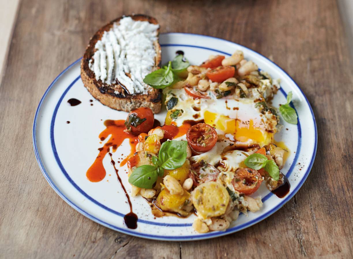 Gebakken eieren met gepofte bonen kerstomaatjes en ricotta op toast