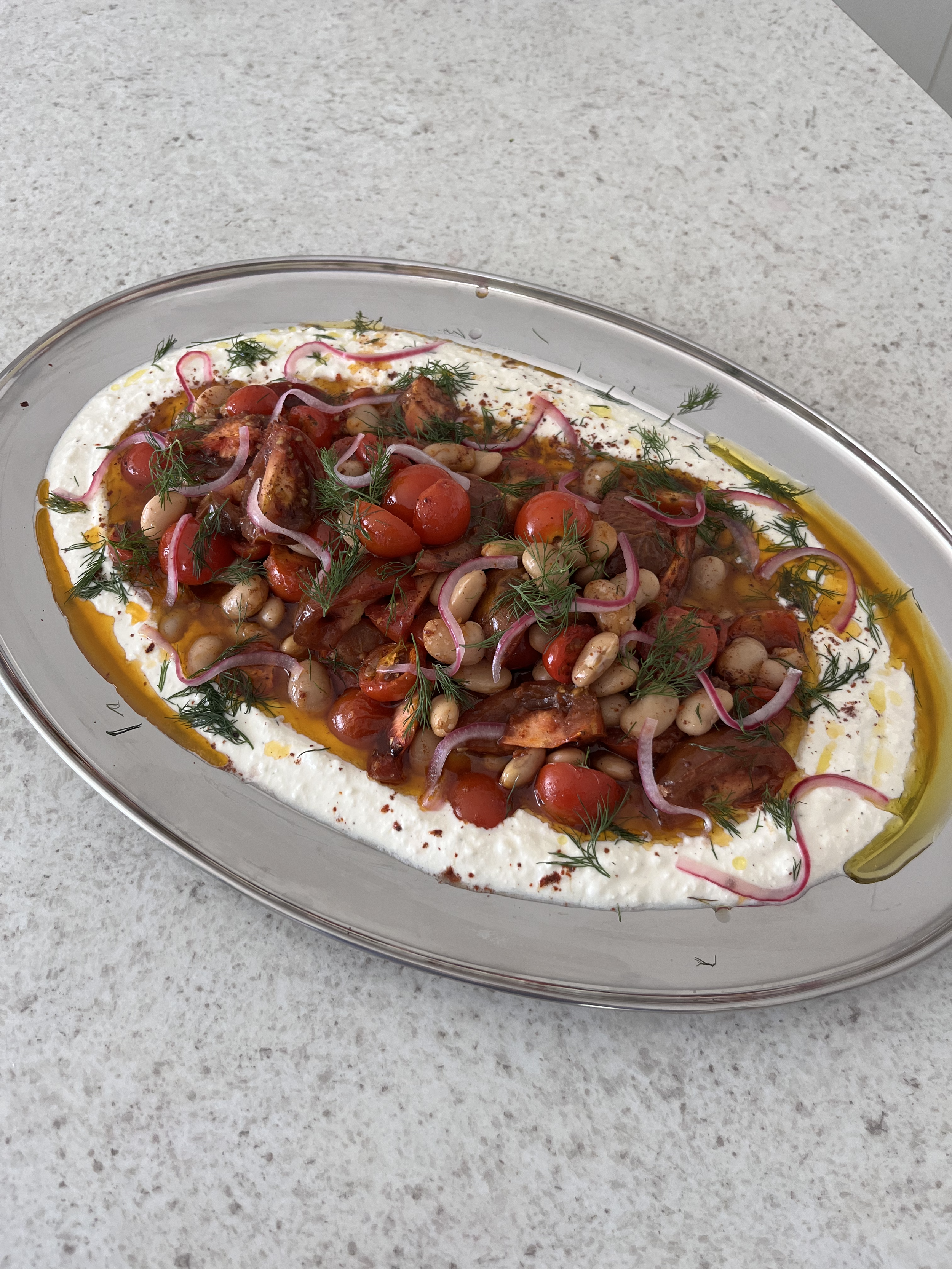 Gekruide geroosterde tomaten en boterbonen met yoghurt en ingelegde rode ui