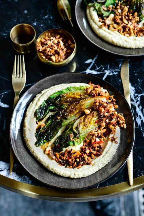 Gebakken Romeinse sla met hummus en krokante kruidentopping