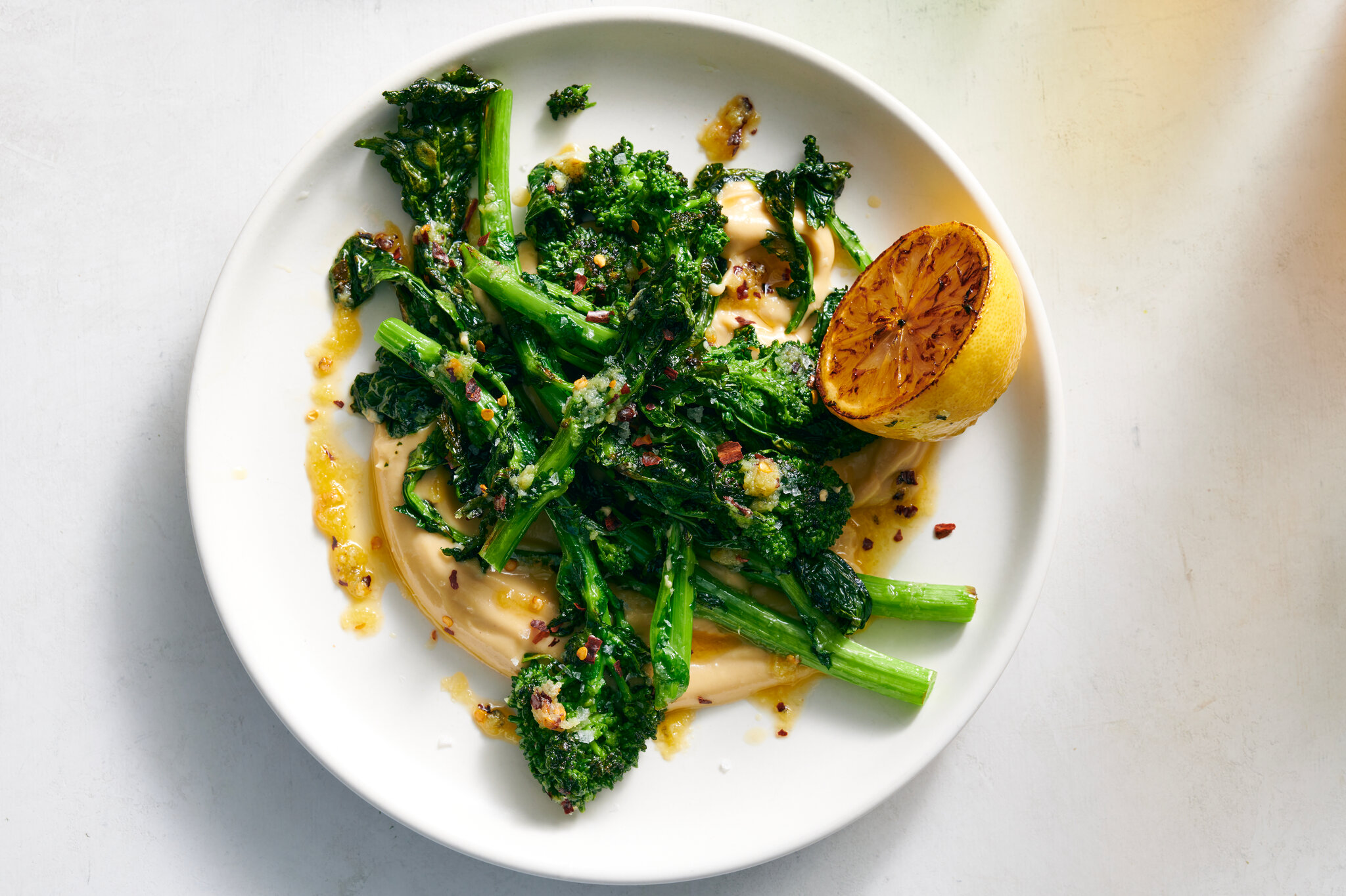 Broccolisteaks, geroosterde knoflook yoghurt en gebrande citroensalsa