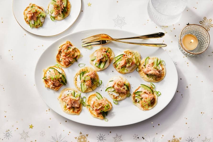 Bli­ni\'s met bos­ui, warm­ge­rook­te zalm en crè­me fraî­che